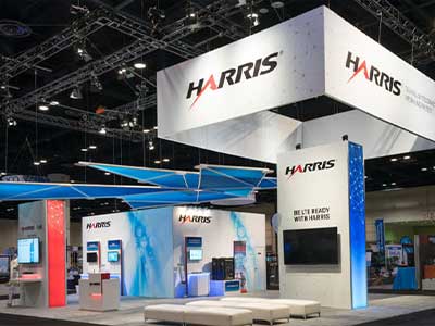 Elegant corporate exhibit booth with branded visuals and ambient lighting, captured by Christie’s Photographic Solutions.