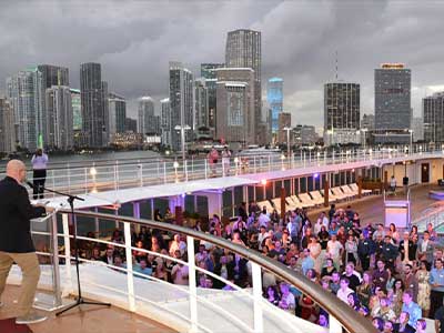 A videographer discreetly capturing a corporate event, showcasing professional event documentation by Christie’s Photographic Solutions