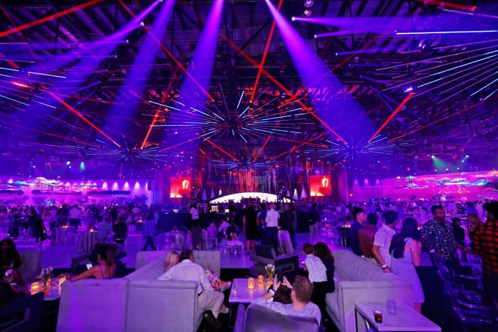 Vibrant corporate gala with dynamic lighting and guest engagement, captured by Christie’s Photographic Solutions.