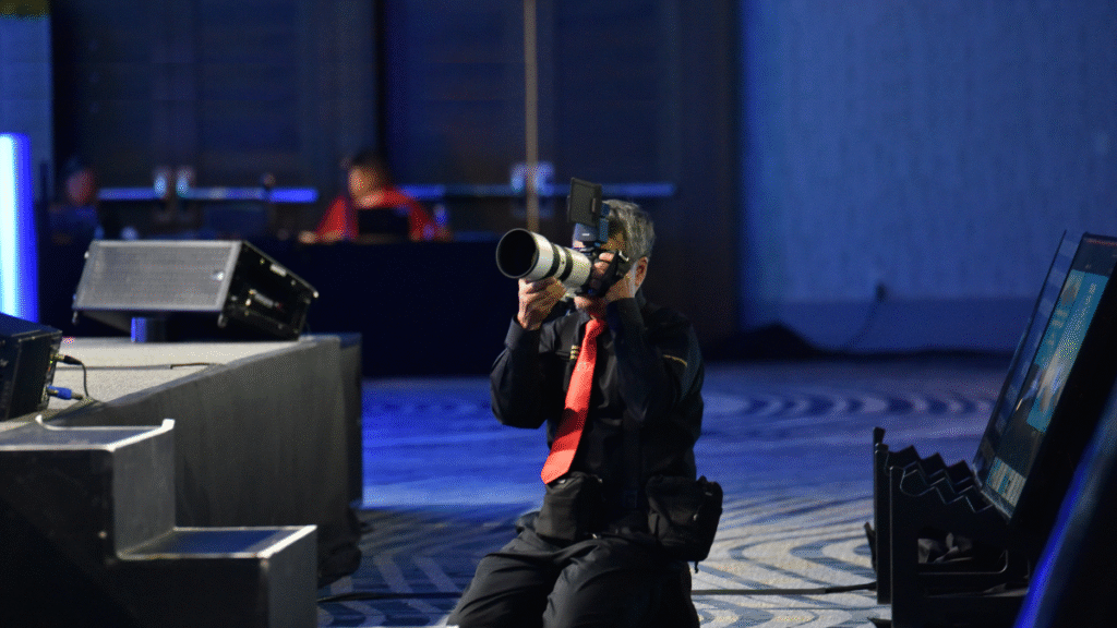 Christie’s Photographic Solutions photographer capturing key event moments from stage-level with long lens and professional lighting setup.