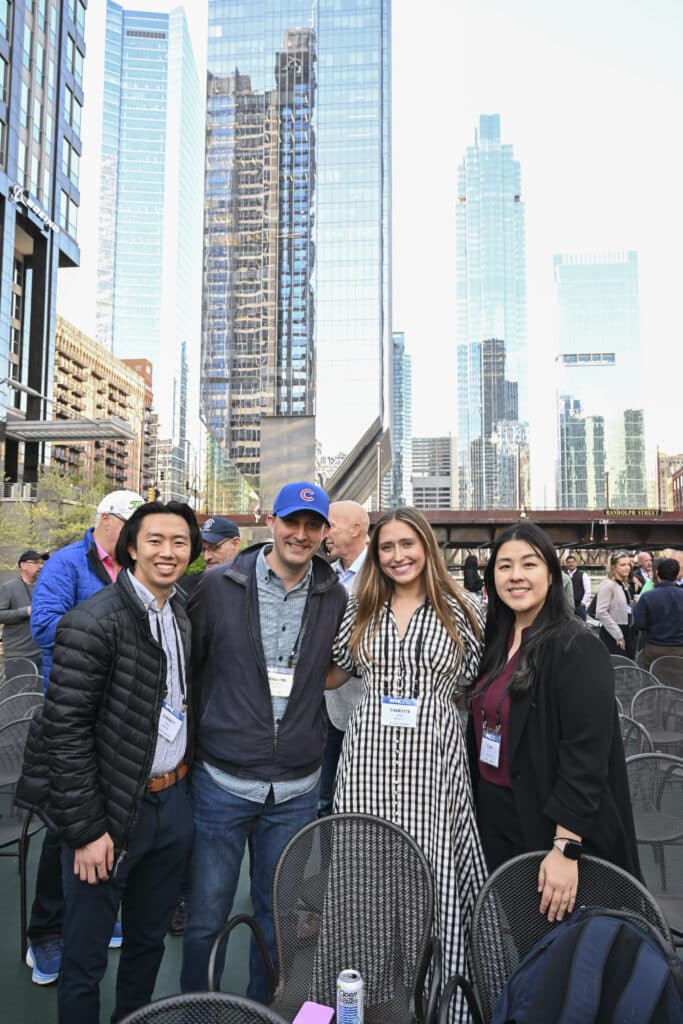 Group of professionals at an outdoor networking event in downtown Chicago with skyscrapers in the background, captured by Christie’s Photographic Solutions.