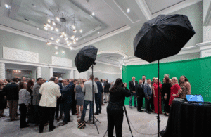 Guests pose for a green screen group photo at a corporate event activation, captured by Christie’s Photographic Solutions.