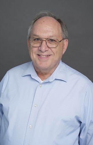 Professional headshot of David Kolvek, Staff Accountant at Christie’s Photographic Solutions, smiling in a light blue button-down shirt.