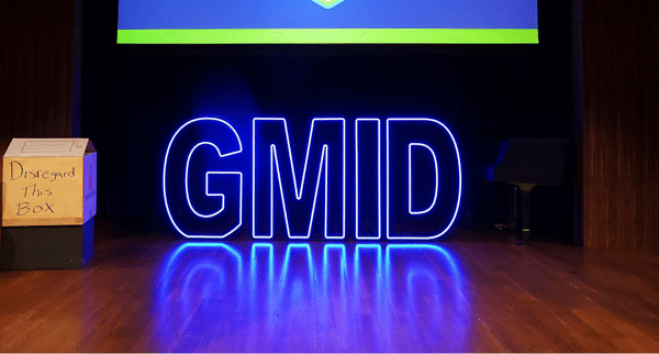Illuminated “GMID” letters on stage beneath a screen celebrating MPI Greater Orlando Chapter’s 40th anniversary, captured by Christie’s Photographic Solutions.