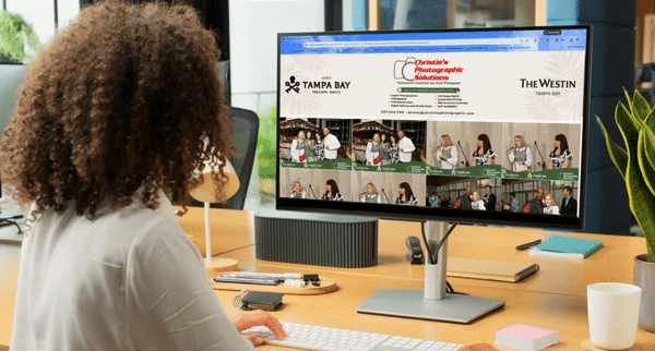 Event professional reviewing an organized online corporate event photo gallery on a desktop monitor, captured by Christie’s Photographic Solutions.