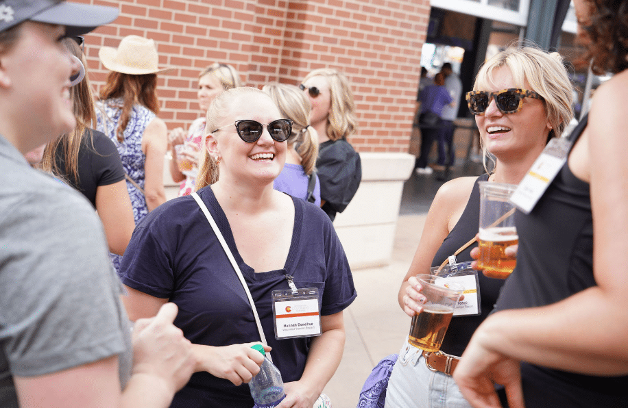 Event attendees enjoying conversation and refreshments during an outdoor corporate networking reception, captured by Christie’s Photographic Solutions.